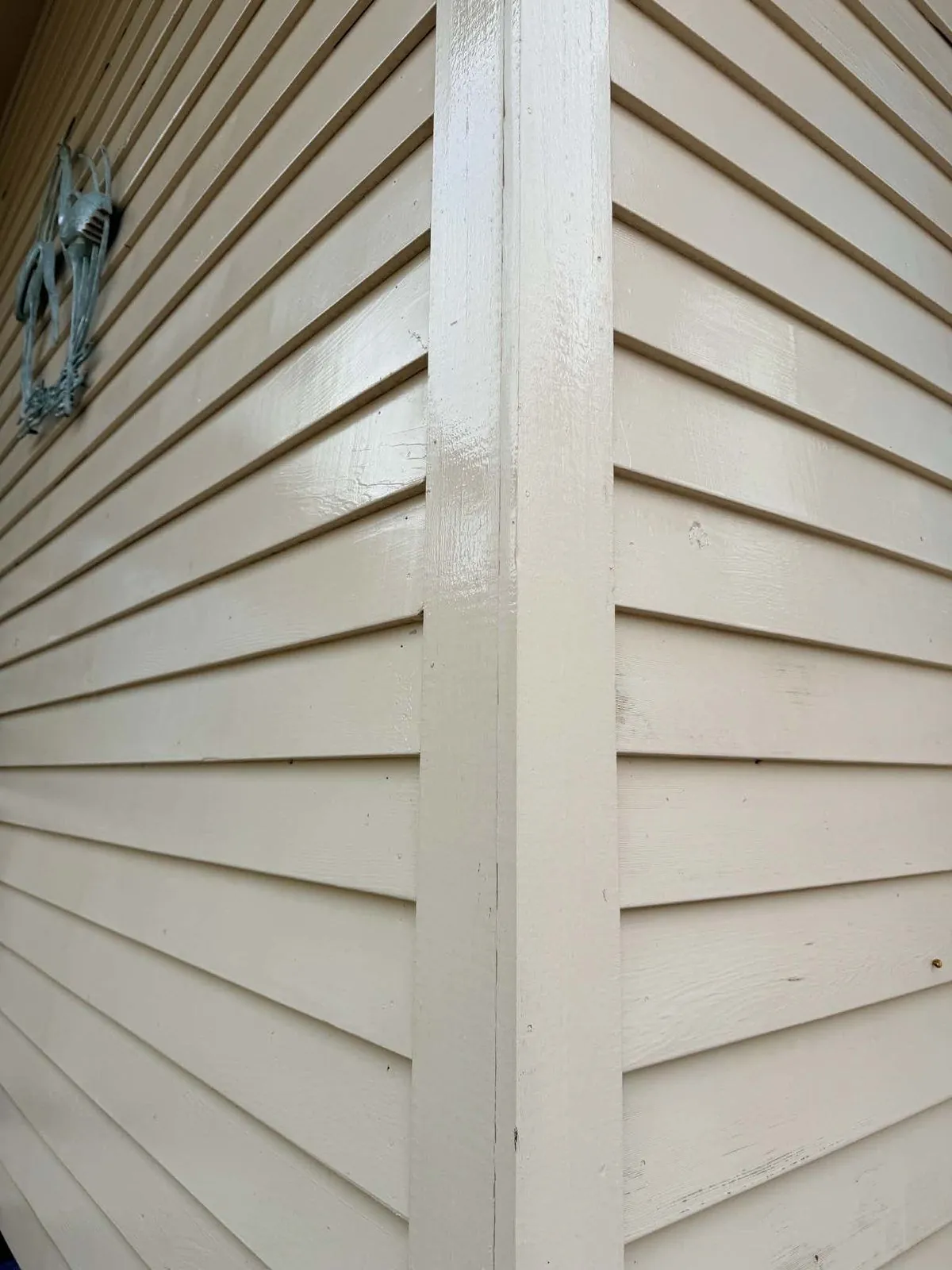 Close-up of clean cream lap siding at a corner board after a house washing