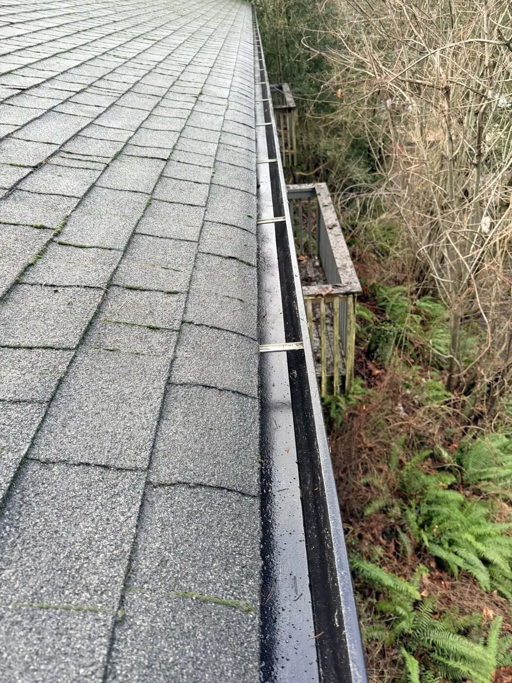 Cleared gutter channel running along a roofline with an open path for water