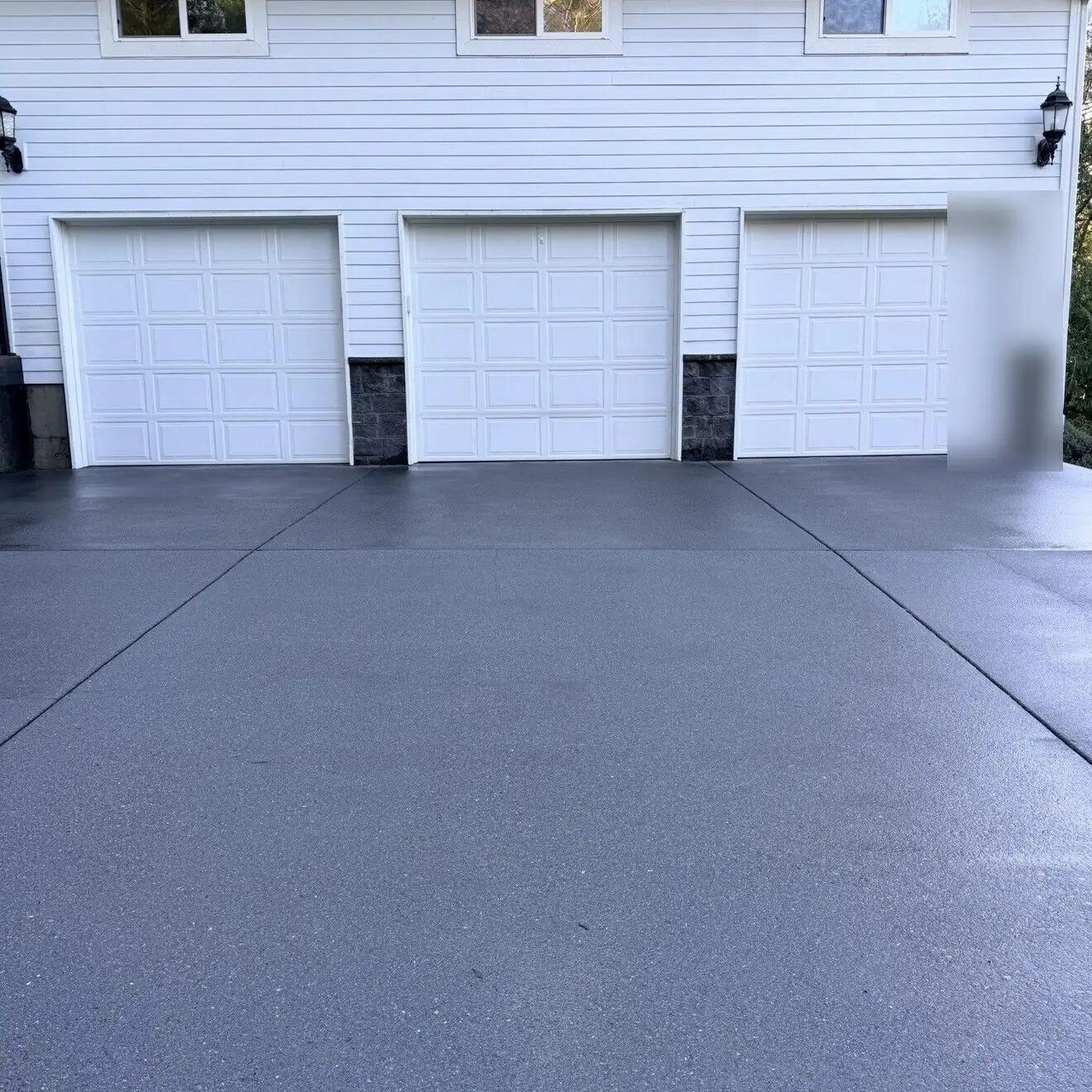 Garage driveway after pressure washing, with an even, clean concrete surface