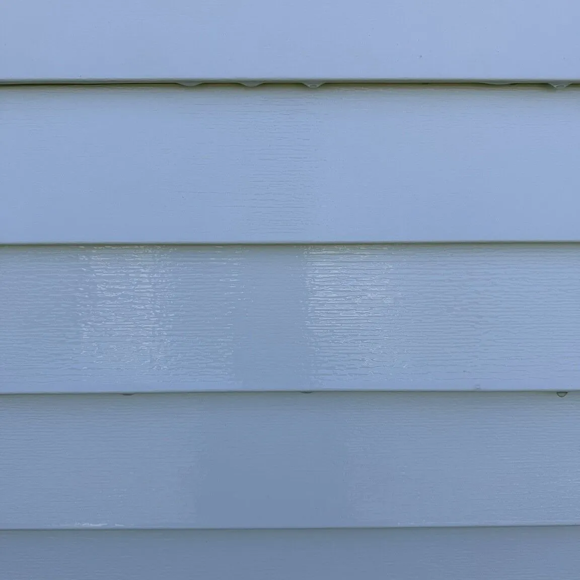 Close-up of lap siding after soft washing, clean and free of organic growth