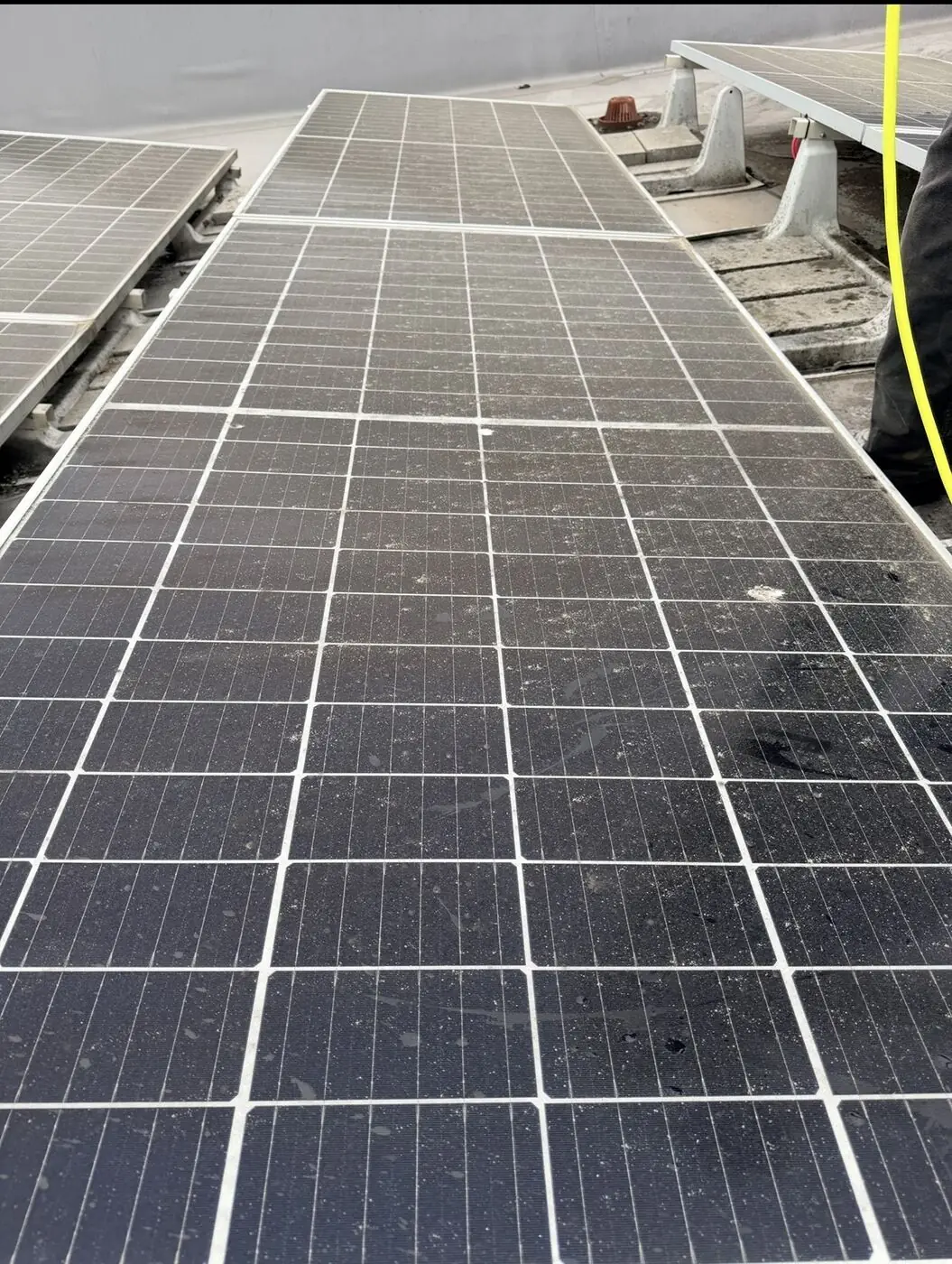 Rows of solar panels coated in dirt, dust and water spotting before cleaning