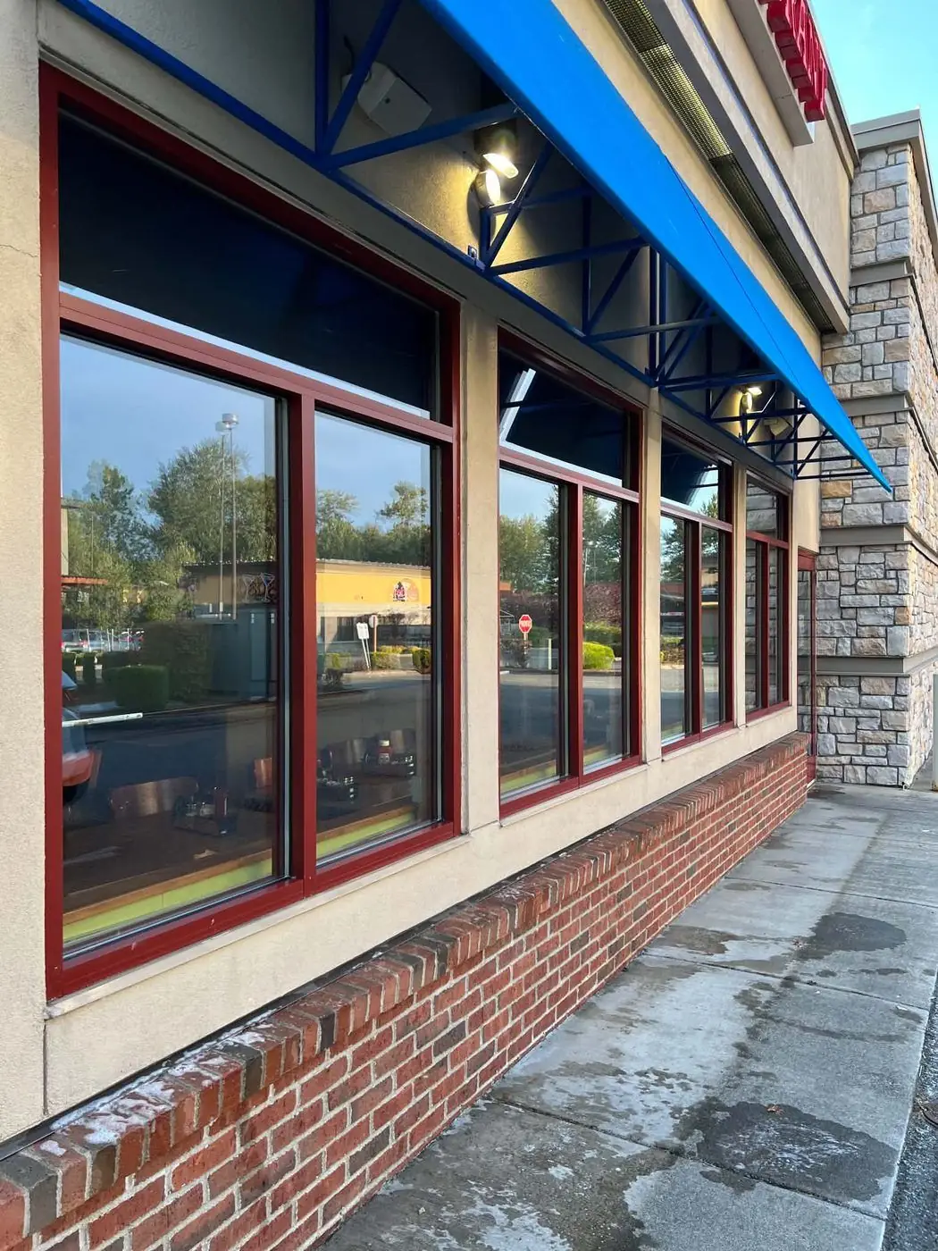 Cleaned storefront windows under blue awnings at a business