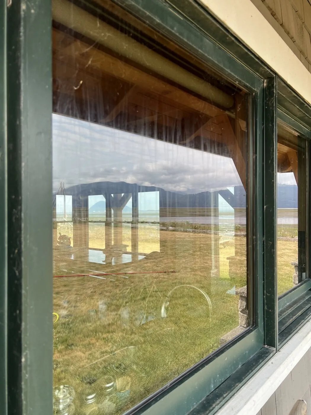Large waterfront window before cleaning, heavy streaking and salt residue clouding the view