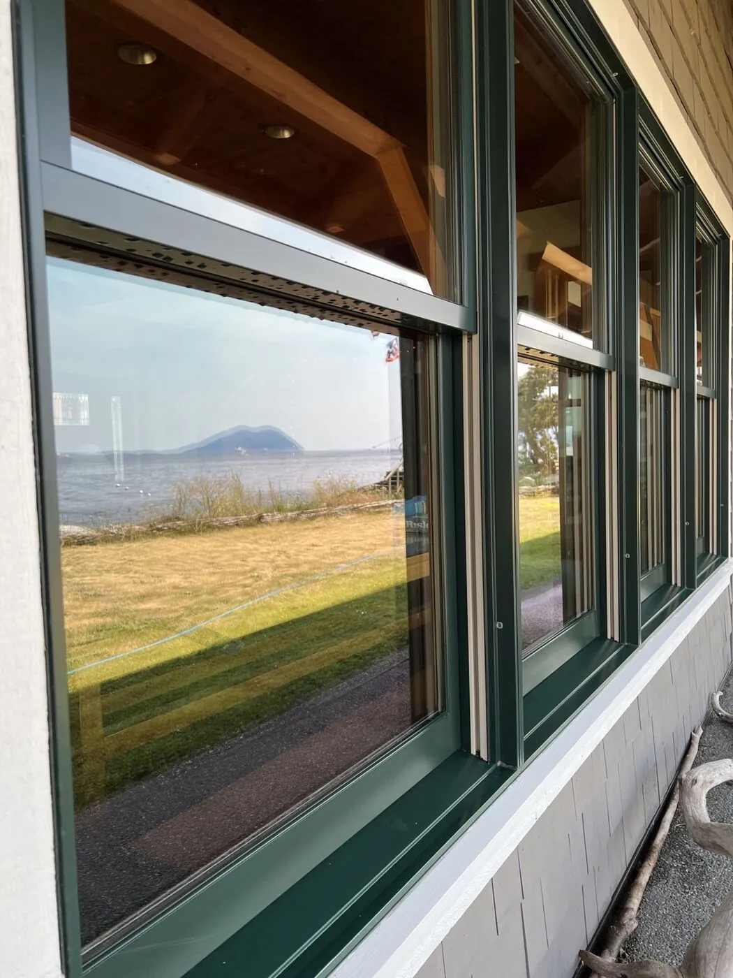 Bank of green-framed windows after cleaning, glass and frames clear